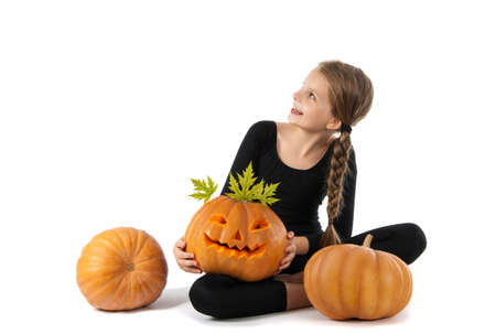 Pretty girl holding a pumpkin. Halloween. The girl smiles. Joy, emotion, holiday.の写真素材
