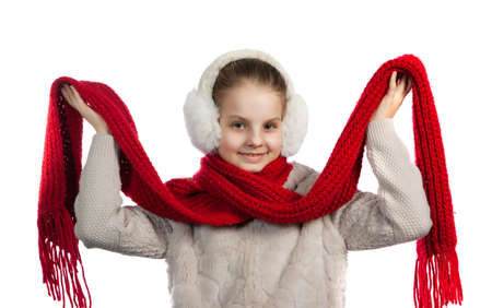 Joyful girl in warm winter things. The girl in fur ear-phones and a blouse with a red knitted scarfの写真素材
