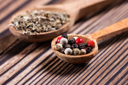 Spices close up in a spoon on a wooden table