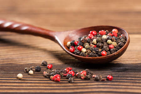 Spices close up in a spoon on a wooden tableの写真素材