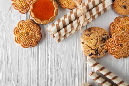 a variety of cookies and sweets on a white wooden table. horizontal view from aboveの写真素材