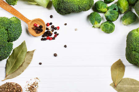 beautiful still life with herbs and spices on a wooden table. Horizontal top view. broccoli, brussels sprouts, bay leaf and spices for soupの写真素材