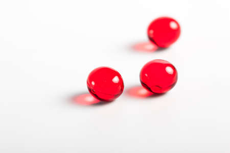 red capsules closeup on a white background. Medical background. Macro. tablets