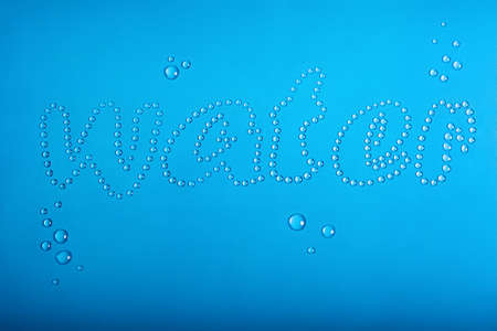 inscription water. made with droplets of water on a blue backgroundの写真素材