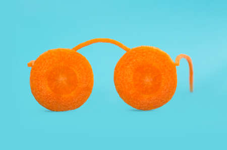 glasses. concept of vision. carrot in the form of glasses on a blue backgroundの写真素材