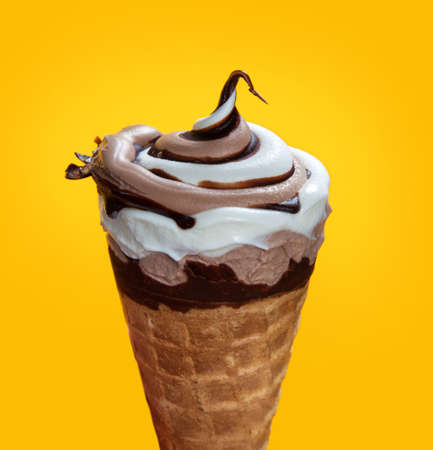 chocolate cream ice cream in waffle cone on yellow background.の写真素材