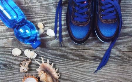 Flat lay photo of sneakers of sports equipment, bottle of water, top view, toned image on wooden background with copy space. Fitness conceptの写真素材