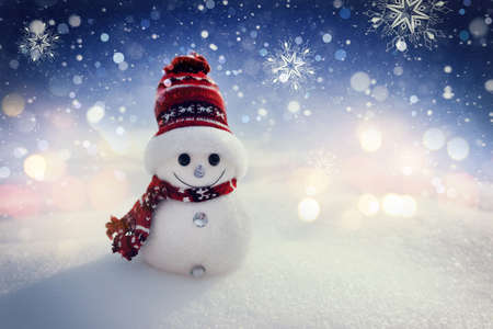 Merry snowman standing in a winter night Christmas landscape. Merry Christmas and Happy New Year...