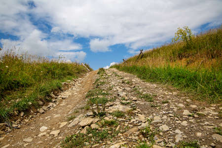 The road goes uphill. stones and soil close upの写真素材