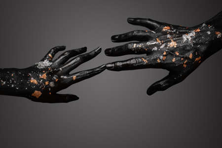Black and gold hands touch. Concept. Contact.の写真素材