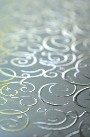 Light silver gray with silver and gold ornamental filigree pattern in metallic vivid color with blurred background and selective focus.  Background for text or copy space.の写真素材