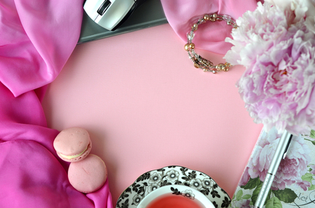 Elegant styled feminine desktop - relaxation, reading, creative writing, learning and journaling concept - with pink peonies, black coffee and stylish stationeryの写真素材