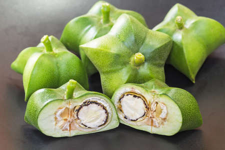 Plukenetia volubilis, sacha inchi, sacha peanut, mountain peanut, Inca-peanut on black plate - half...