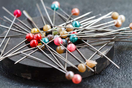 Pins attach round magnetic pincushion on black leather background