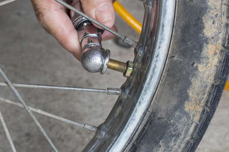 Hand Inflating a motorcycle tire with dirty wheelの写真素材
