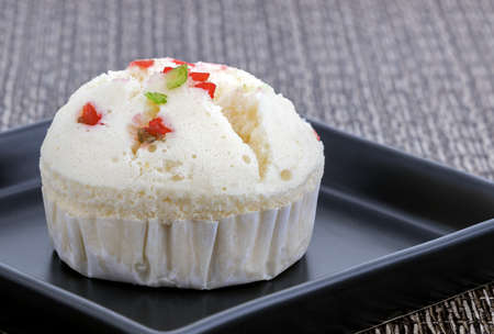 Khanom Puifai - cotton ball cakes with dried fruit on black dish on matt.の写真素材