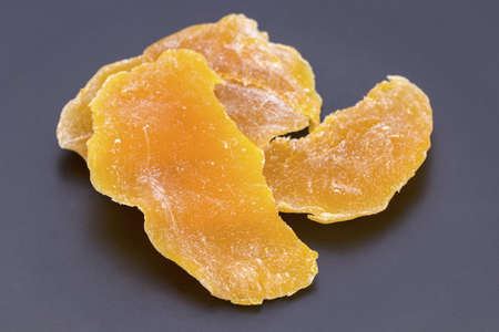 Dehydrated(dried) organic ripe Mango on black plateの写真素材