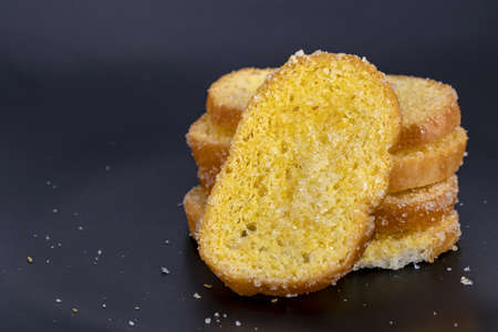 Delicious crisp sliced butter toast on black plate