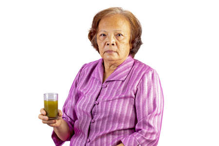 Old aged asian woman holding green tea cup by using one hand isolated on white backgroundの写真素材