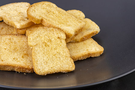 Butter golden crispy bread topping sugar on black plateの写真素材