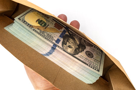 Hidden Fortune: A hand tenderly holds an open envelope overflowing with crisp hundred-dollar bills,...
