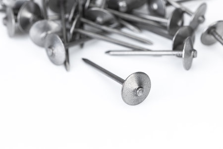 A pile of roofing nails on a white background is an essential metal hardware for construction and repair work.の写真素材
