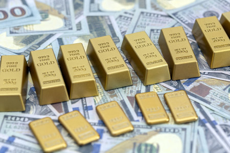 A gold bars and cash are arranged on background of scattered currency, symbolizing wealth and financial security. image conveys sense of prosperity and investment potentialの写真素材