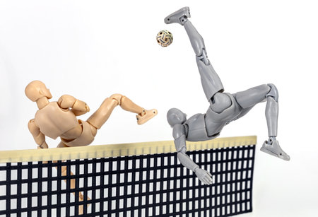 Attacker figurine performs dynamic sunback spike and blocking  in sepak takraw, showcasing agility and balance. figure is mid air, emphasizing athleticism and motion against white backgroundの写真素材
