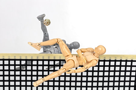 Attacker figurine performs dynamic half somersault spike and blocking in sepak takraw, showcasing agility and balance. figure is mid air, emphasizing athleticism and motion against white backgroundの写真素材