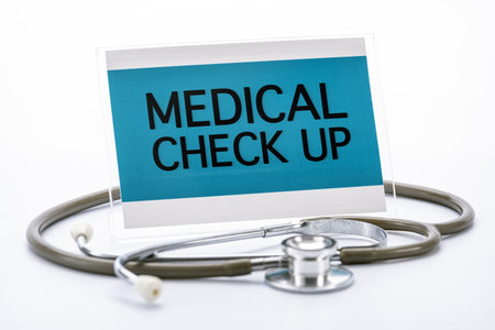 A stethoscope encircles sign reading medical check up on white background, symbolizing healthcare and wellnessの写真素材