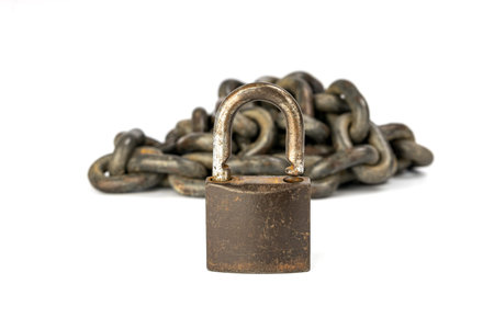 The image captures a rugged metal padlock in the foreground, with a backdrop of intertwined chains,...