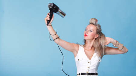 pin up girl retro style portrait woman drying hair with electric fanの写真素材