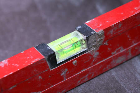 level Construction worker is tiling at home, tile floor adhesive