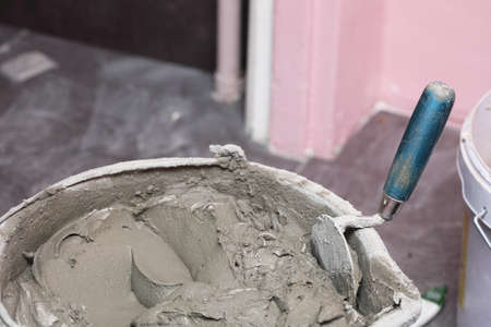 Construction worker is tiling at home, tile floor adhesiveの写真素材