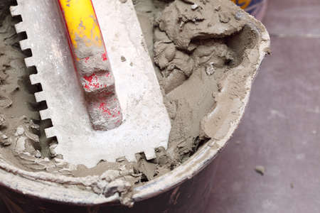 Construction worker is tiling at home, tile floor adhesiveの写真素材