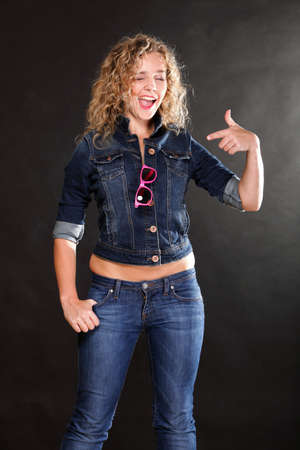 Young beautiful woman with long curly blond hair on grey backgroundの写真素材