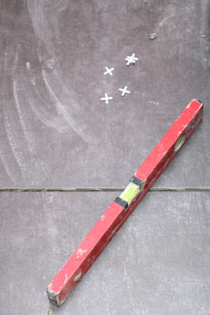 level Construction worker is tiling at home, tile floor adhesiveの写真素材