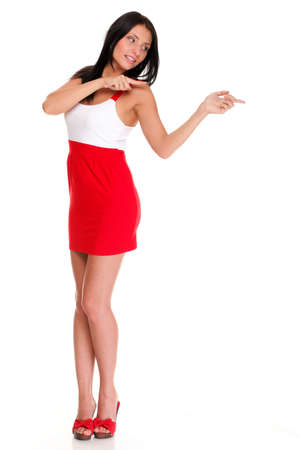 Sexy latin in short red hot dress isolated Pointing and looking to the side. Casual young business woman looking, pointing and smiling at copy space.の写真素材