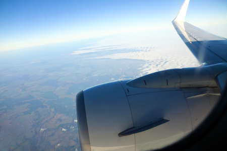 Airplane in the blue sky engine and wings white clouds