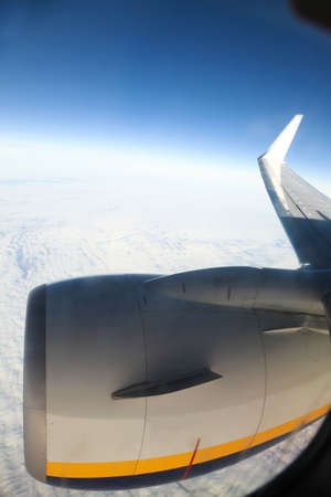 Airplane in the blue sky engine and wings white clouds