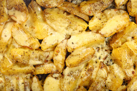 Roasted potatoes with spices and cheese as backgroundの写真素材
