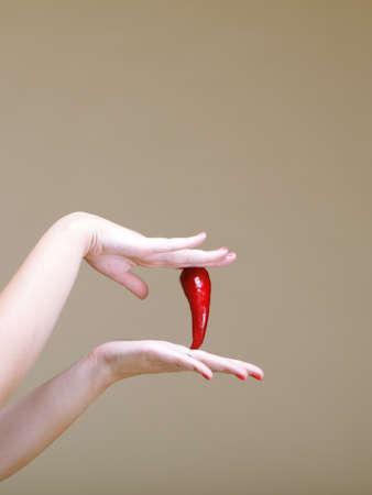 chili pepper in female hand  brown backgroundの写真素材