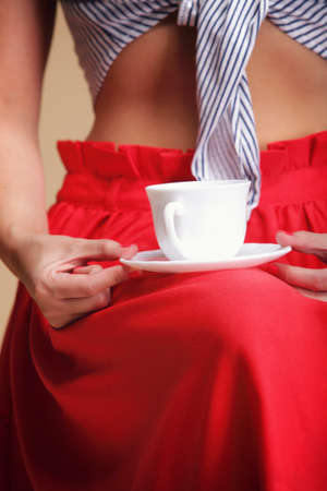 Woman holding tea or coffee. Cup of hot beverage brown backgroundの写真素材