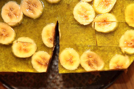 Fruit jelly cake with slices of banana as backgroundの写真素材