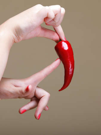 chili pepper in female hand  brown backgroundの写真素材