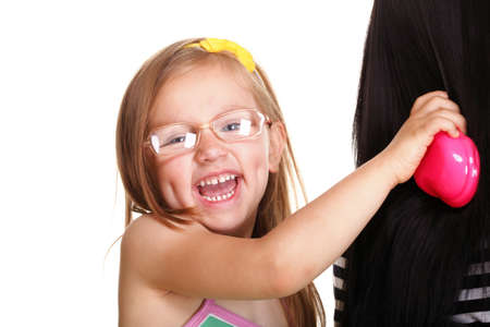 happy family, cute three year old litle baby girl brushing her mothers hairの写真素材