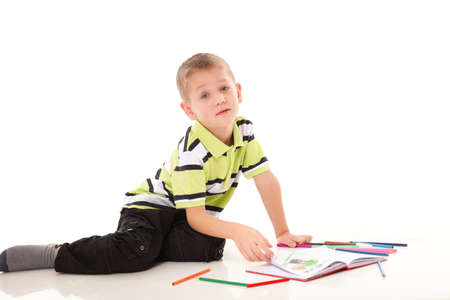 little boy drawing with color pencils on floor isolated on white background