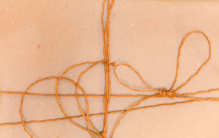 A recycle knot wrapping on orange packing paper backgroundの写真素材