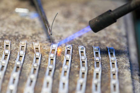 Closeup jeweller at work silver soldering. Goldsmith working and welding.の写真素材