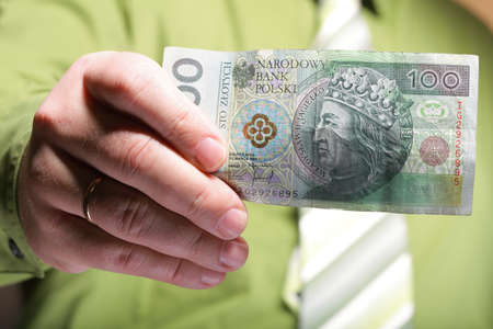 Businessman holding polish money hundred zloty banknoteの写真素材